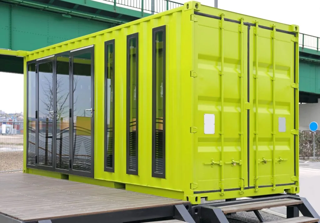 Lime green container kiosk with full-height glazing